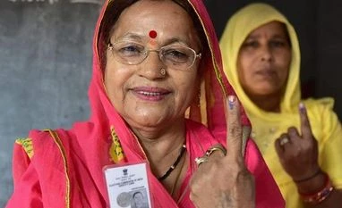 LS polls: Cong MLA Pawan Kajal to fight BJP's Kishan Kapoor in HP's Kangra Voters show their identity cards as they stand in a queue at a polling station to cast their vote for the state assembly elections in Jodhpur. Photo: PTI