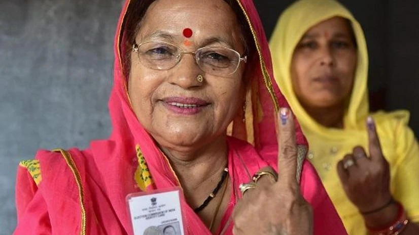 Voters show their identity cards as they stand in a queue at a polling station to cast their vote for the state assembly elections in Jodhpur. Photo: PTI Voters show their identity cards as they stand in a queue at a polling station to cast their vote for the state assembly elections in Jodhpur. Photo: PTI