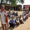 Voter show their identity cards as they wait in a queue to cast their votes during the first phase of the general elections, at a polling station in Nawada district of Bihar