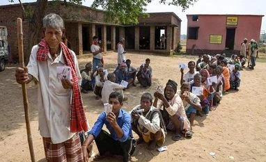 NDA builds lead in Bihar, is ahead in 36 of 40 seats versus Cong-RJD's four Voter show their identity cards as they wait in a queue to cast their votes during the first phase of the general elections, at a polling station in Nawada district of Bihar