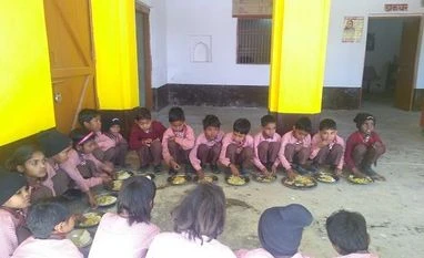 Learning from the classroom Students gather around for their mid day meal at the primary school in Jayapur