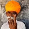A voter shows his finger marked with indelible ink after casting vote at a polling station