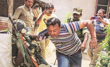 I don't want to share dais with expiry-PM as elections are on: Mamata A jawan pushes away a miscreant at a polling station in Bangaon constituency of Nadia district on Monday (Photo: PTI)