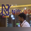 Technical indicators show strong support for Nifty: Is it time to buy dips? A man talks on phone at the National Stock Exchange as its new logo for for the benchmark Nifty50 is seen on a glass-wall, in Mumbai