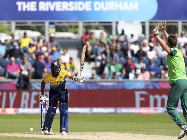 Sri Lanka's captain Dimuth Karunaratne, left, walks off after being dismissed by South Africa's bowler Kagiso Rabada, middle Sri Lanka's captain Dimuth Karunaratne, left, walks off after being dismissed by South Africa's bowler Kagiso Rabada, middle