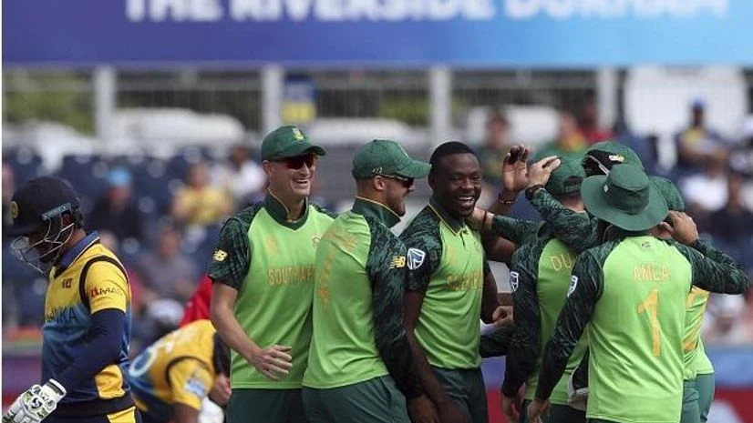 Sri Lanka's captain Dimuth Karunaratne, left, leaves the crease after being dismissed by South Africa's bowler Kagiso Rabada, middle Sri Lanka's captain Dimuth Karunaratne, left, leaves the crease after being dismissed by South Africa's bowler Kagiso Rabada, middle