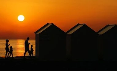 World Coronavirus Dispatch: Pandemic upends France's eating habits People walk beside beach cabins on a pebbled beach, during sunset as a heatwave hits France, in Cayeux-sur-Mer. Photo: Reuters