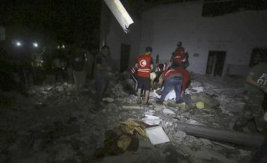 India at UNSC calls for elections in Libya, hopes issues resolve peacefully Libyan Red Crescent workers recover migrants bodies after an airstrike at a detention center in Tajoura, east of Tripoli | Photo: AP/PTI