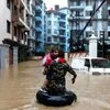 A member of Nepalese army carrying a child walks along the flooded colony in Kathmandu, Nepal Photo: Reuters