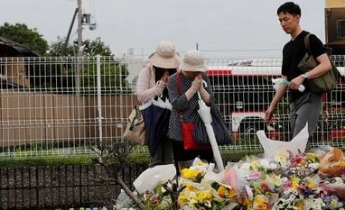 I don't have words: Boss of torched Japan animation studio mourns staff People pray in front of a row of flowers placed for victims of the torched Kyoto Animation building on Saturday. Photo: Reuters