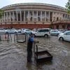 A worker stands on a waterlogged street at Parliament after heavy rain, in New Delhi