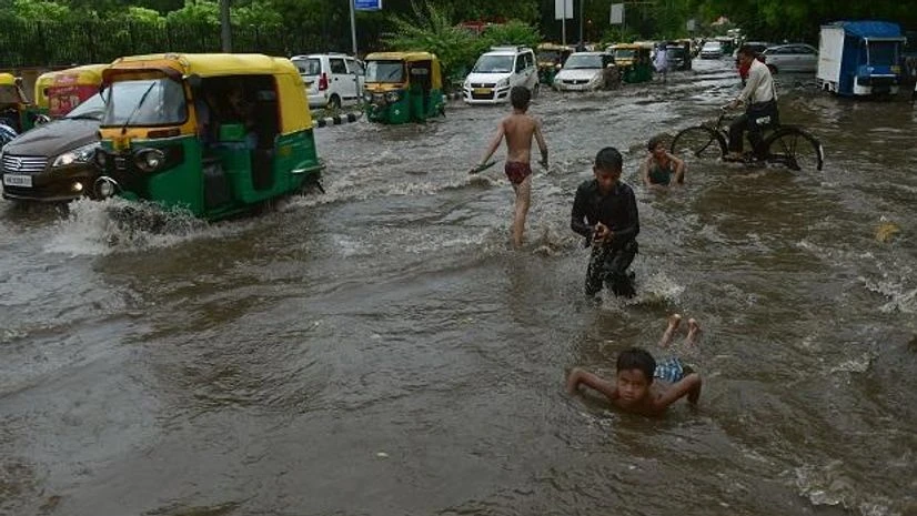 Children play while vehile ply at a waterlogged road after rains, in New Delhi Children play while vehile ply at a waterlogged road after rains, in New Delhi