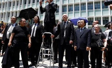 Hong Kong lawyers hold silent march in solidarity with anti-govt protesters Lawyers and workers in Hong Kong's legal sector gather outside the Department of Justice during a protest in Hong Kong, China August 7, 2019. REUTERS/Thomas Peter