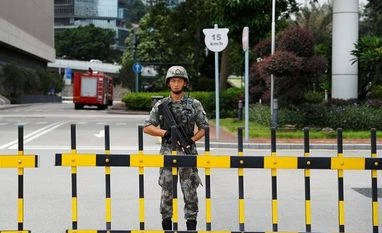 China's Hong Kong-stationed troops complete new rotation: State media A Chinese People's Liberation Army (PLA) soldier guards the entrance to the PLA Hong Kong Garrison headquarters in the Central Business District in Hong Kong