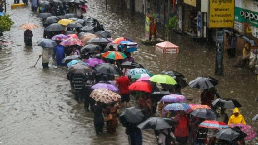 People wade through a flooded street during heavy rain, in Mumbai People wade through a flooded street during heavy rain, in Mumbai