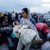 A woman holds her baby as refugees and migrants arrive on a passenger ferry from the island of Lesbos at the port of Piraeus</headline>  <by>GIORGOS MOUTAFIS