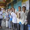 Karad: Voters stand in a queue and show their voting cards as they wait to cast their votes at a polling station for the Maharashtra Assembly elections, in Karad, Monday, Oct. 21, 2019. (PTI Photo)