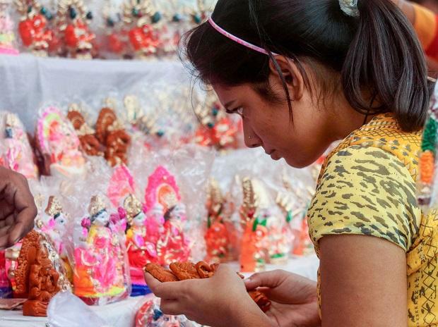 A young woman buys an idol of goddess Laxmi on the occasion of Dhanteras festival ahead of Diwali, in Varanasi A young woman buys an idol of goddess Laxmi on the occasion of Dhanteras festival ahead of Diwali, in Varanasi