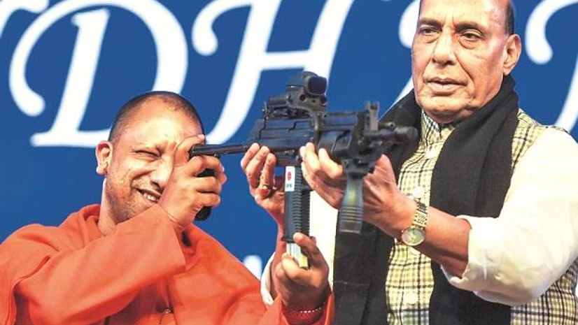 Defence Expo, DefExpo, Uttar Pradesh Chief Minister Yogi Adityanath checks a gun held by Defence Minister Rajnath Singh (right) at the 11th edition of DefExpo, in Lucknow, on Friday | Photo: PTI
