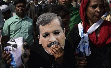 aap, delhi elections, delhi election results, app workers AAP volunteers hold a cut-out of Delhi CM Arvind Kejriwal during swearing-in ceremony at Ramlila Maidan in New Delhi. (Photo: PTI)