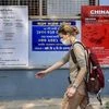 Kolkata: A tourist wears a mask as she walks past the posters on awareness towards COVID-19 during her arrival for a health checkup, at ID & BG Hospital in Kolkata. (PTI Photo/Swapan Mahapatra)