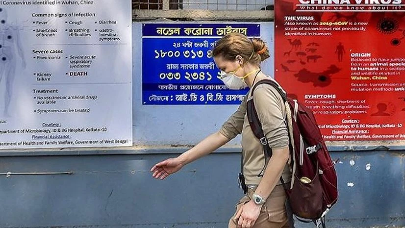Coronavirus, west bengal, kolkata Kolkata: A tourist wears a mask as she walks past the posters on awareness towards COVID-19 during her arrival for a health checkup, at ID & BG Hospital in Kolkata. (PTI Photo/Swapan Mahapatra)