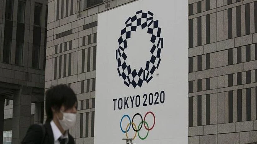 A man walks past a large banner promoting the Tokyo 2020 Olympics in Tokyo. File Photo: AP | PTI Tokyo Olympics