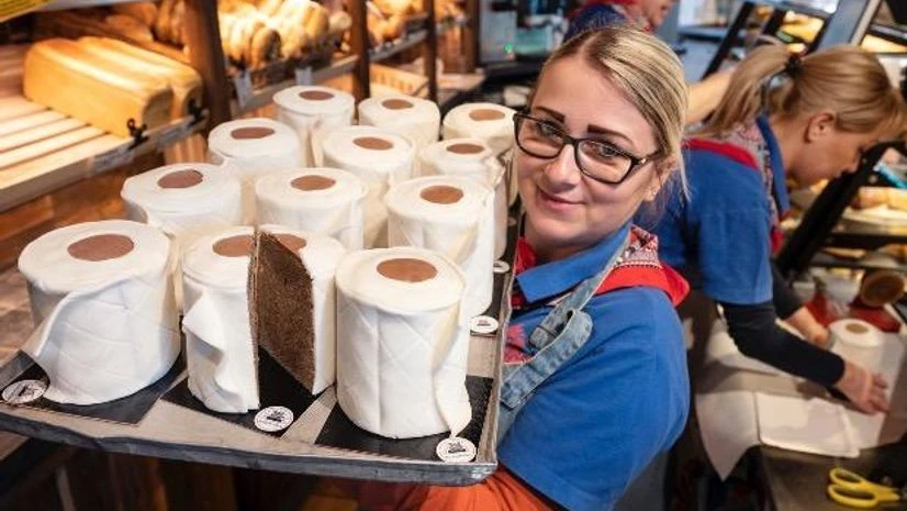 Coronavirus A saleswoman of the bakery Schuerener Backparadies shows a tray with round marble cakes wrapped in fondant that look like toilet paper rolls in Dortmund, Germany. The toilet paper cake has become a "bestseller" during the Corona crisis. Photo: PTI