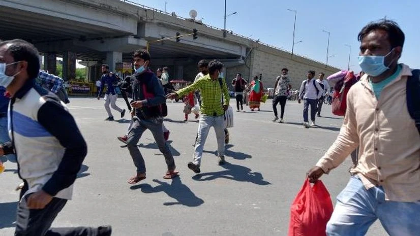 coronavirus, migrant workers Migrants run to board a bus to their native village, during a nationwide lockdown imposed in the wake of coronavirus pandemic, at Ghazipur Delhi - UP border, Ghaziabad. Photo: PTI