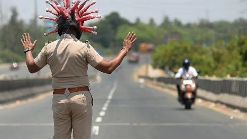 coronavirus A police officer, wearing a helmet depicting coronavirus, requests commuters to stay at home during a nationwide lockdown to limit the spread of the virus, in Chennai. Photo: PTI