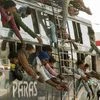 Migrant workers try to reach out for food packets being distributed by volunteers as they leave in an overloaded bus to their respective destinations, during the nationwide lockdown in wake of the coronavirus pandemic, in Patna. Photo: PTI