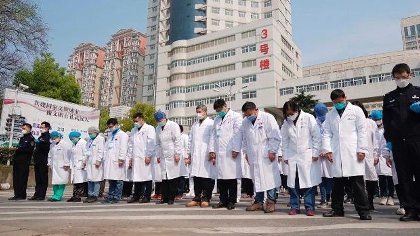 coronavirus, China In this photo released by Chinas Xinhua News Agency, medical workers bow their heads during a national moment of mourning for victims of coronavirus in Wuhan in central Chinas Hubei Province. Photo: PTI