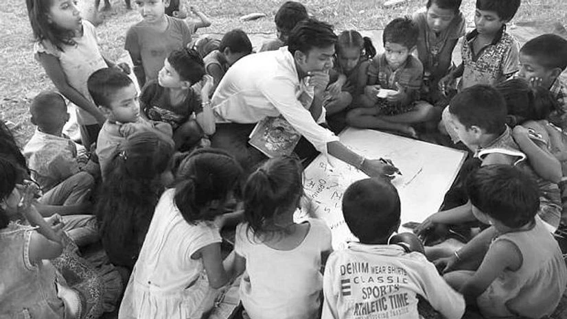 Pechaan Live Foundation A man teaching poor kids in a street school of Pechaan Foundation
