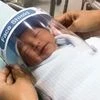 A nurse adjusts tiny face shield for a newborn baby to protect from new coronavirus at the newborn nursery of the hospital in Samutprakarn province, central Thailand. Photo: PTI