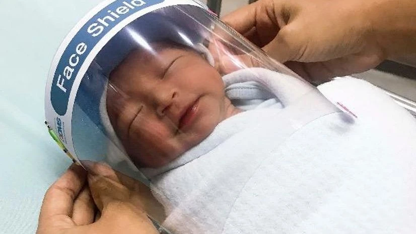 A nurse adjusts tiny face shield for a newborn baby to protect from new coronavirus at the newborn nursery of the hospital in Samutprakarn province, central Thailand. Photo: PTI A nurse adjusts tiny face shield for a newborn baby to protect from new coronavirus at the newborn nursery of the hospital in Samutprakarn province, central Thailand. Photo: PTI