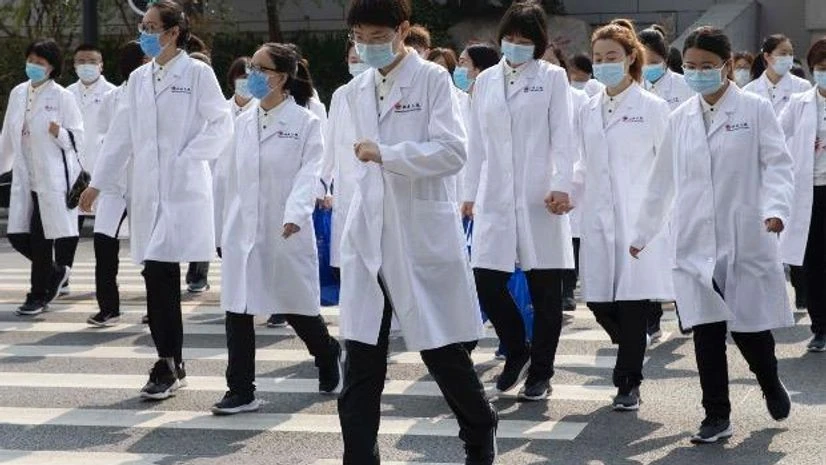 coronavirus, China Medical workers from Beijing walk near a park during a day off as the city of Wuhan slowly loosens up ahead of a lifting of the two month long lockdown in central China's Hubei province. Photo: PTI