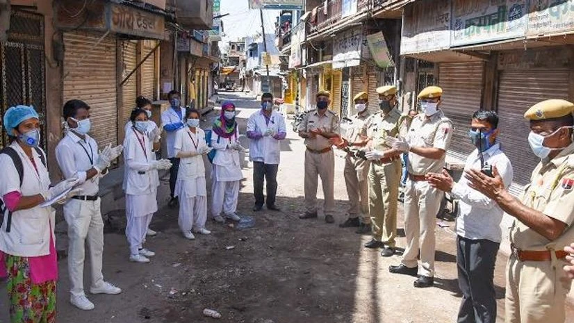 coronavirus, doctor, police Medics and police personnel clap as locals obey the nationwide lockdown in the wake of coronavirus outbreak, near Nagori gate in Jodhpur. Photo: PTI