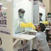 Medical staff members of a government-run medical college collect swabs from people to test for Covid-19 at a newly installed walk-in sample kiosk in Kerala's Ernakulam Photo: Reuters
