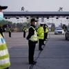 Police officers stand guard at a toll station of an expressway. Photo: Reuters