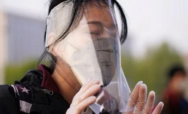 Chinese doctor accuses local officials of Covid-19 cover-up in Wuhan market A traveller adjusts her face shield outside Hankou Railway Station. Photo: Reuters