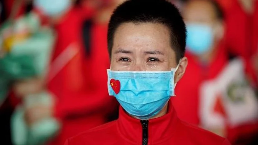 coronavirus, China A member of a medical team weeps at the Wuhan Tianhe International Airport after travel restrictions to leave Wuhan, the capital of Hubei province and China's epicentre of the novel coronavirus disease (COVID-19) outbreak, were lifted. Photo: Reuters