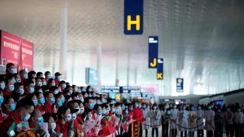 coronavirus, China Members of a medical team pose for a group photo at the Wuhan Tianhe International Airport after travel restrictions to leave Wuhan were lifted. Photo: Reuters