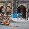 Police offical take rest after dispersing hundreds of stranded migrant workers from outside the Bandra Railway Station in Mumbai. Photo: PTI