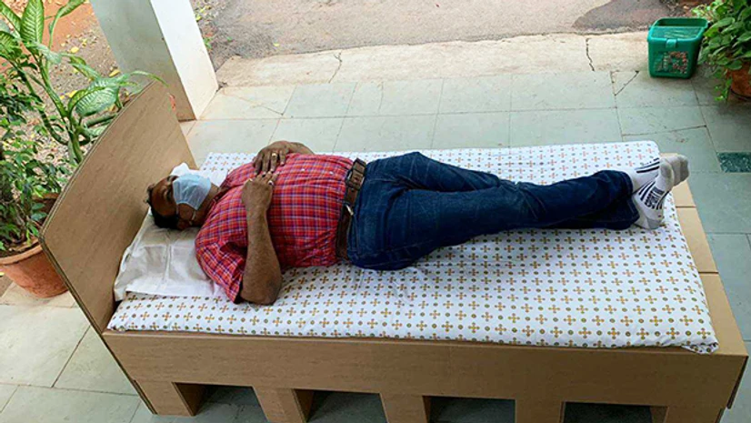 cardboard bed, Aryan Paper A person resting on the low-cost cardboard beds prepared for Covid-19 patients.