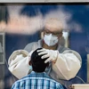 A medic collects a swab sample of a man from a new swab testing cabin at Podar hospital in Worli during a nationwide lockdown in the wake of coronavirus pandemic, in Mumbai. Photo: PTI