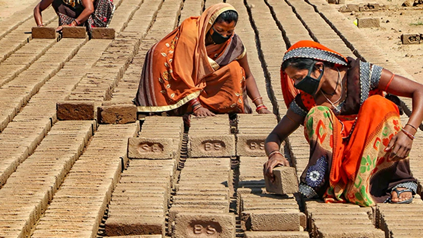 Coronavirus, Covid-19, lockdown, social distancing Labourers wearing face masks work at a brick kiln factory during the nationwide lockdown to curb the spread of coronavirus, on the outskirts of Jammu. Photo: PTI
