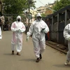 Health workers wearing protective outfits seen in a street during ongoing COVID-19 lockdown in Kolkata. Photo: PTI