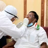 Puducherry Chief Minister V Narayanasamy gives swab sample to a medic for COVID-19 test, in Puducherry. Photo: PTI