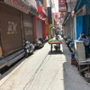 A view of a market with only a grocery shop is opened and a vegetable vendor is seen crossing it, during ongoing Covid-19 lockdown in Lucknow. Photo: PTI