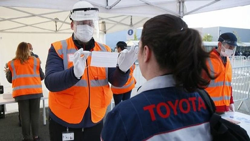 france, coronavirus, face mask An employee is being instructed on how to use a face mask at the Toyota car factory in Onnaing, northern France, Monday, April 27, 2020. Workers are returning to a Toyota factory as the country tries to carefully restart the economy. AP/PTI